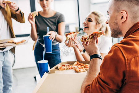 愉快的企业家团体在办公室开业时一起吃披萨共进午图片