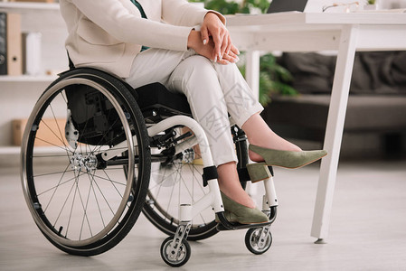 坐在轮椅上双腿交叉的残疾女商图片
