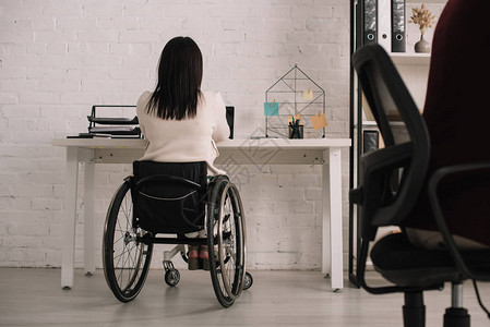 坐在轮椅工作场所的残疾女商图片