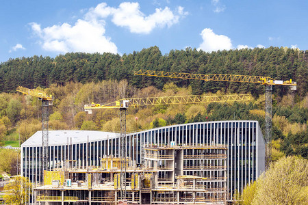 绿色山丘背景中带有起重机的工业建筑图片