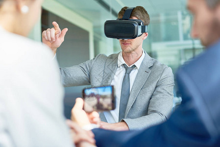 利用VR头盔与宽敞的会议室的同事讨论启动项目的同时图片