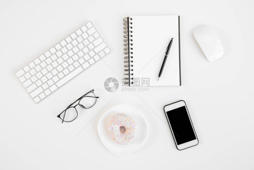 工作场所带空白屏幕的智能手机带笔眼镜键盘电脑鼠标和美味甜圈的空白笔图片