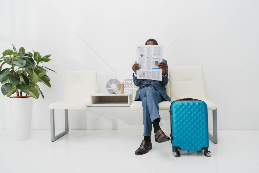 坐在候诊室和阅读报纸上的非洲美国商界人士图片