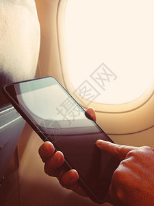 商人坐在飞机上看他的手机图片