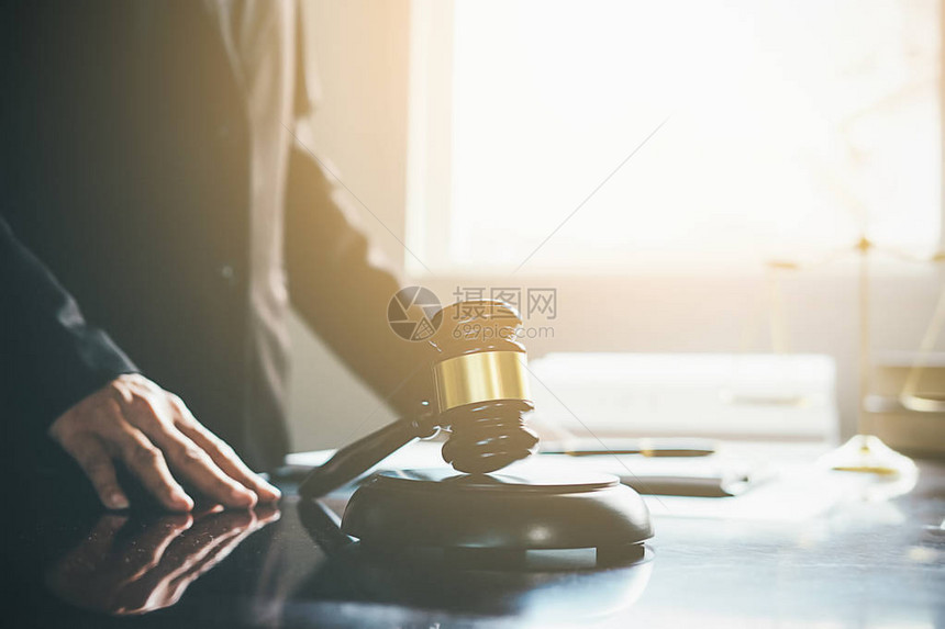 正义和法律概念法律顾问向客户出示与木槌和法律或法律在后台在律师事务所举行团队会议图片