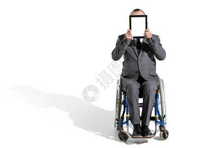 坐在轮椅上用数字平板电脑隔离在白色上的残疾人图片