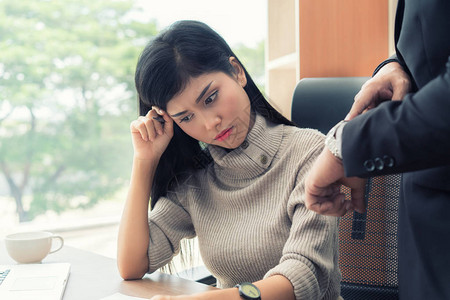 愤怒的商业经理用手表指着从属女商人图片