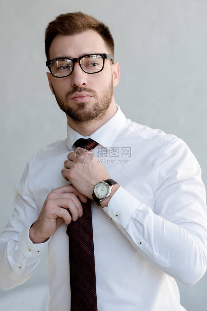 穿着领带和戴眼镜的自信商人在白图片