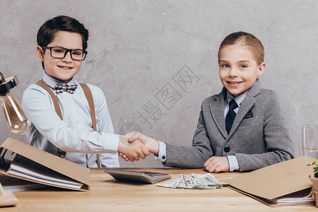 微笑的caucasian儿童握手和在工作场所图片