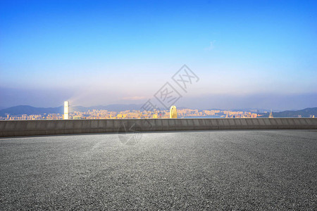 从空荡的柏油路上看的城市景观背景图片