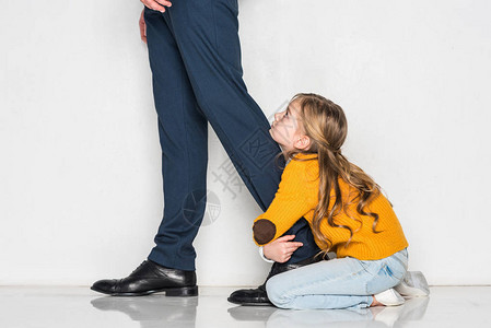 女儿抱父亲在商业西装中孤立于灰色图片