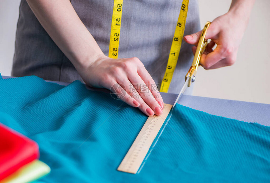 女裁缝在服装缝纫合测量织物上工作图片