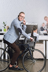 在办公室自行车上耳机上的呼叫中心操作员图片