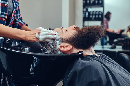 专业美发师在理发店为客户洗头图片