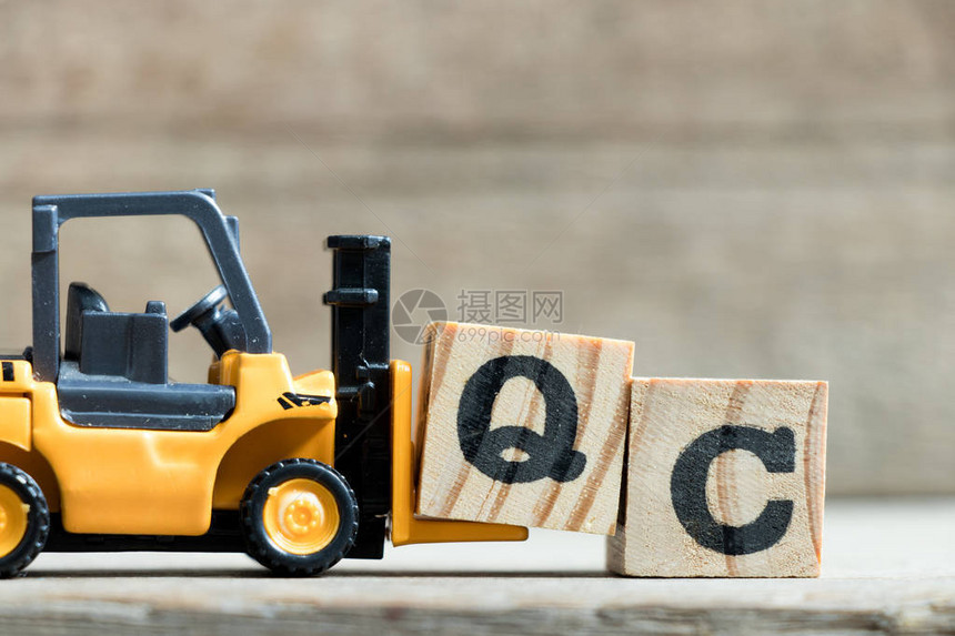 玩具黄色叉车在木本上填全QC质量控制缩写字图片