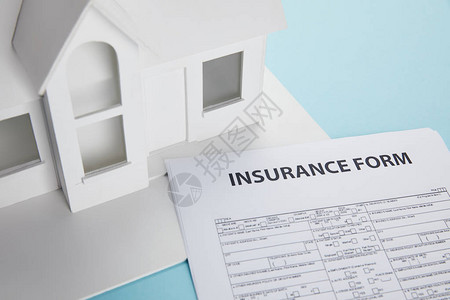 保险表格和蓝色小房屋模型图片