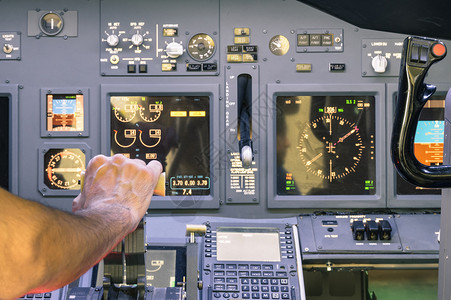 机长在商业客机飞行模拟器起飞阶段的驾驶舱推力控制杆上加速油图片