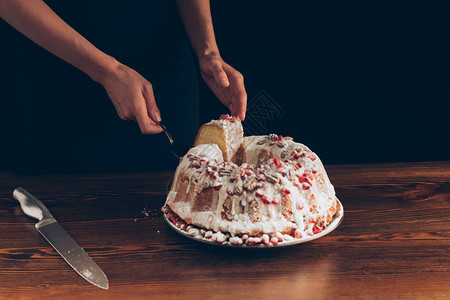 妇女用石榴和坚果切传统圣诞节蛋糕图片