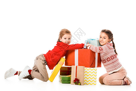 快乐的小孩坐在地板上带着一大堆圣诞礼物图片