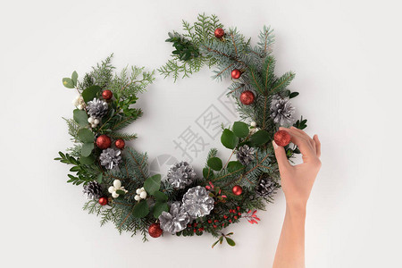 切成以鲜树枝圣诞球松果和寄生虫为单位的手制作圣诞节花环的作物形视图片