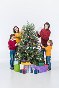 幸福的家庭装饰圣诞树礼物与白图片
