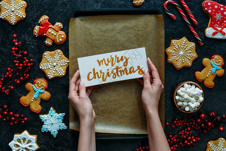 用自制姜饼和烘烤盘上圣诞快乐贺卡的手工图片