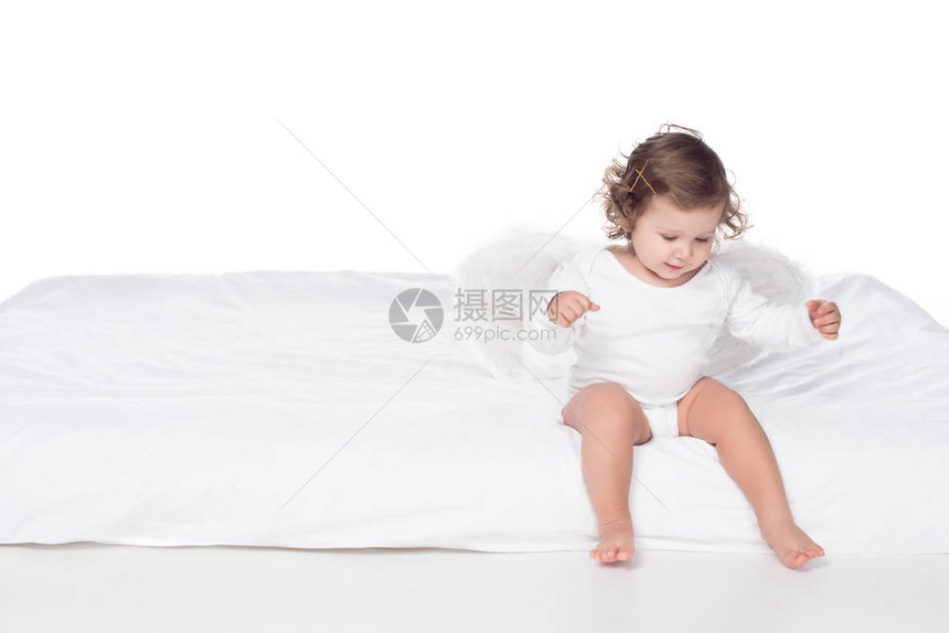 可爱的快乐婴儿翅膀坐在床上图片