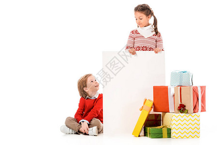 长着圣诞礼物和白纸板的可爱小可爱小孩在图片