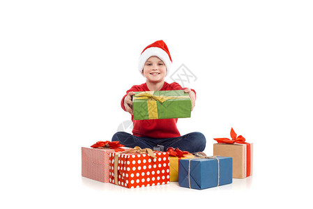 戴着圣诞礼物的圣塔帽的小男孩图片