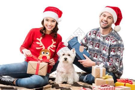 坐在地板上与狗和圣诞礼物一起坐在床图片