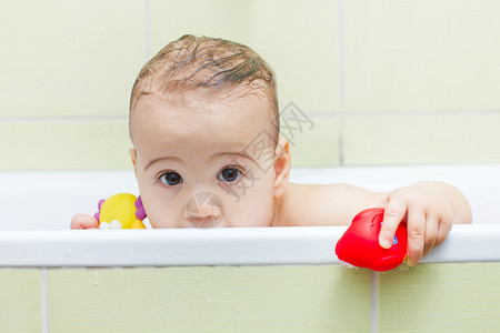 婴儿洗澡时从浴缸里偷看背景图片