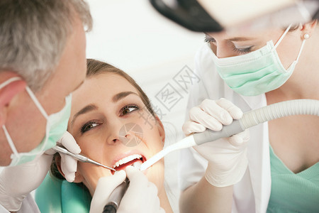 牙科治疗助理戴面罩和手套牙医和助理图片