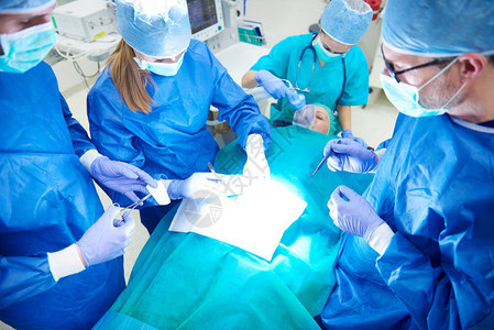 繁忙的外科医生小组在手背景图片