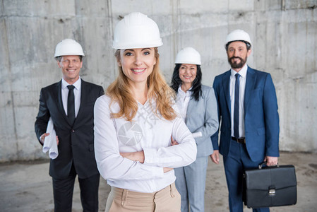 身戴头盔的建筑师专业团队站在一起图片