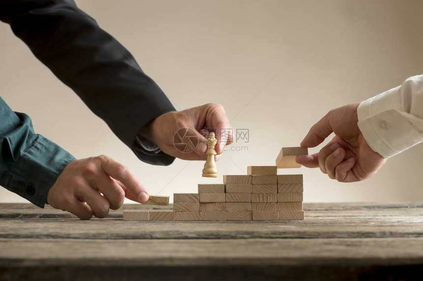 商业团队理念与商人将棋子皇后移动到由他的团队放置的块形成的图片