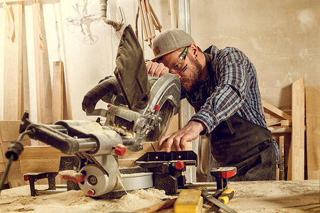 经验丰富的木匠使用圆锯切割木板男工人或有电动工具的得力图片