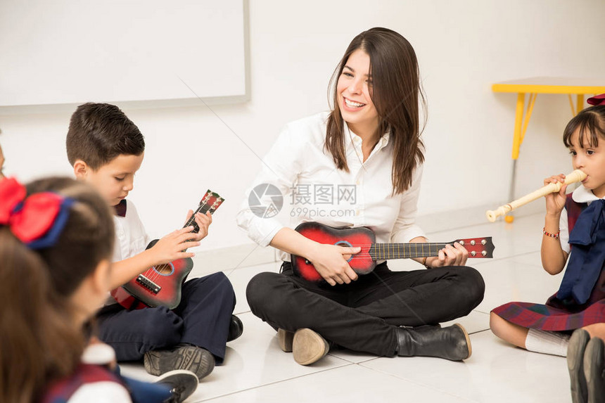 玩乐的学前女教师弹吉他向学生图片