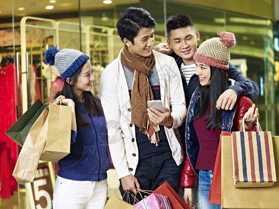 两对亚洲夫妇在商场或百货公司购物圣诞节时使用图片
