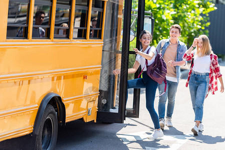 快乐的青少年学生走进校车图片