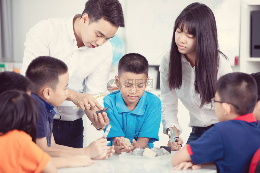 快乐的男老师在教室里向一群年轻学生图片