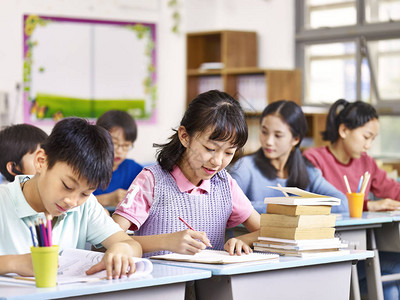 亚裔小学男女学生在班级学习单位背景图片