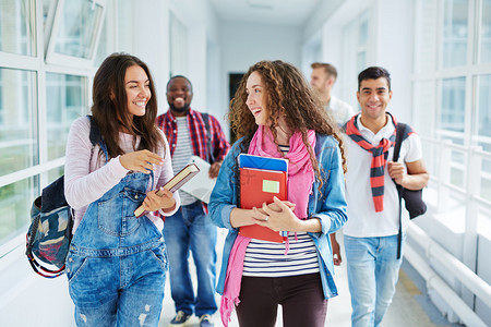 快乐的少女沿着大学走廊在大学走廊上图片