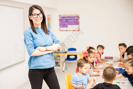 神经紧张的学龄前教师站在一个满教室的教室里图片