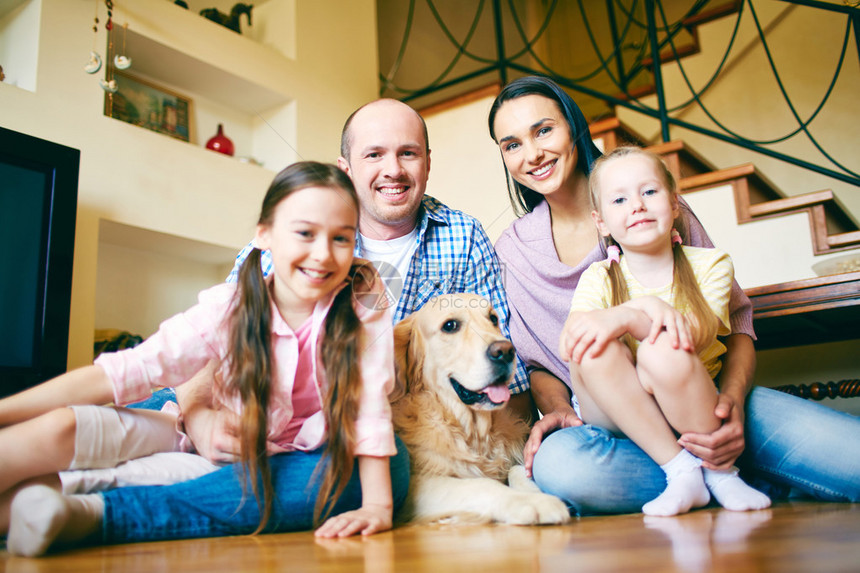 一家四口的年轻友好家庭和他们的狗图片