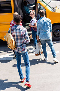 一群青少年学者放学后步行乘校车到校图片