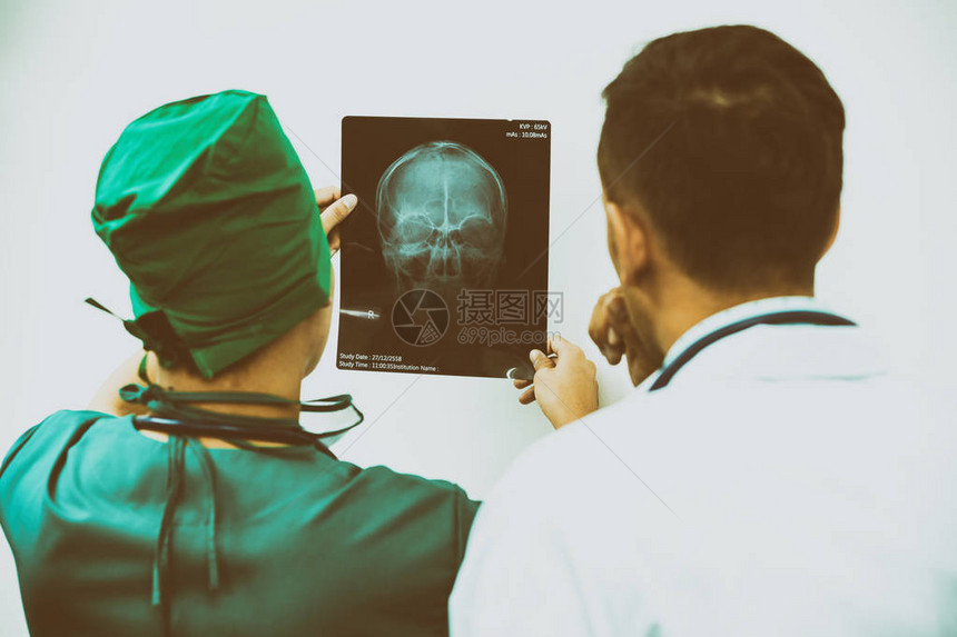 医生和外科医生检查病人脑部头骨或眼部受伤的X光片图片