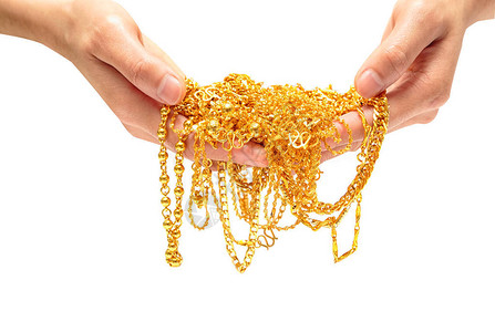 手拿着昂贵的金首饰项链和手链图片
