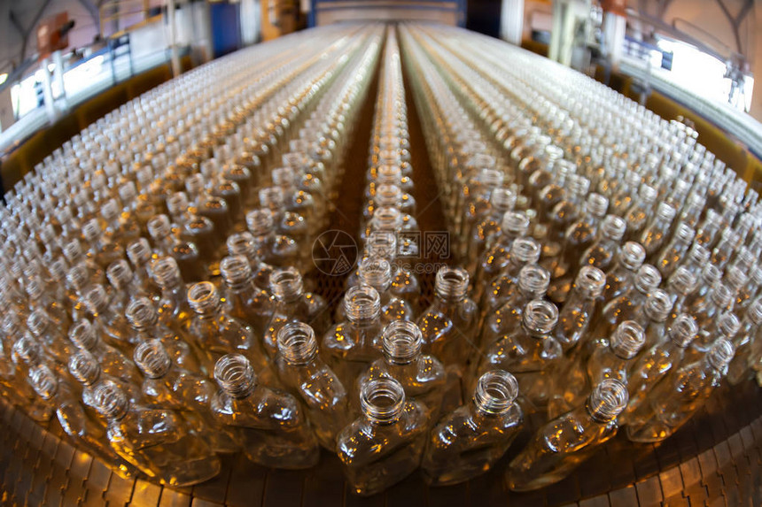 玻璃工业工厂传送器上有很多玻璃瓶子图片