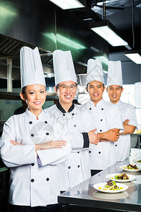 亚洲印度尼西亚和厨师以及餐厅或酒店商业厨房烹饪完成菜或盘图片