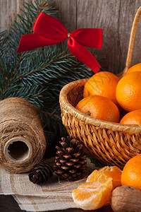 新鲜有机成熟的橘子在旧木本底的篮子图片